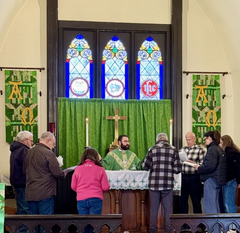 Fr. Bryan celebrating the Wednesday evening Eucharist at the altar, with parishioners gathered around